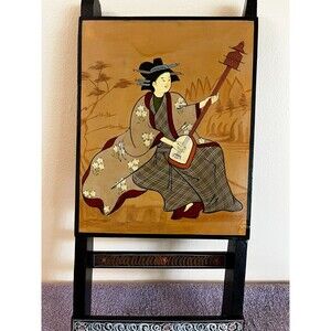 Geisha playing a shamisen, a traditional Japanese three-stringed instrument